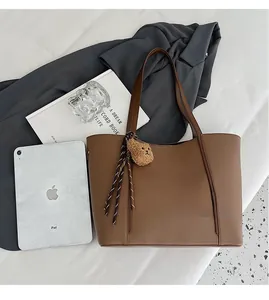 Coffee brown tote bag showing large capacity by fitting an iPad and several books