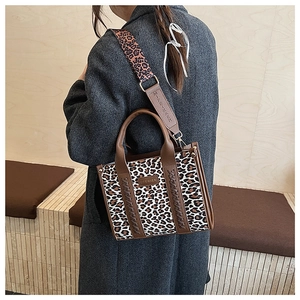 Details der Leopard-Canvas-Tasche mit braunem Lederbesatz und breitem Schultergurt