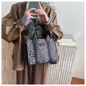 Detailansicht der Leopard-Print Tragetasche mit schwarzem Lederbesatz und Webdetails