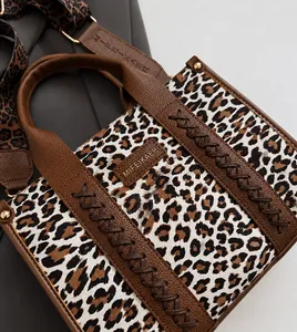 Nahaufnahme der Leopard-Tasche mit braunem Lederbesatz und strukturiertem Schultergurt