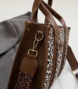 Nahaufnahme des goldenen Metallverschlusses und Leopard-Riemens der Vintage-Tasche