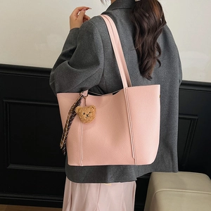 Pink lychee texture tote bag with plush bear charm and scarf shown on model