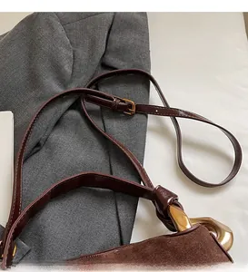 Détails de sac en daim marron foncé avec ferrures dorées et bandoulière réglable