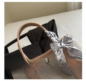 Detail of contrast stitching tote bag with woven fabric texture and silk scarf handle