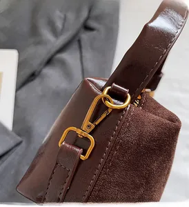 Détail d'un sac à main en cuir marron avec crochets rotatifs et anneaux dorés