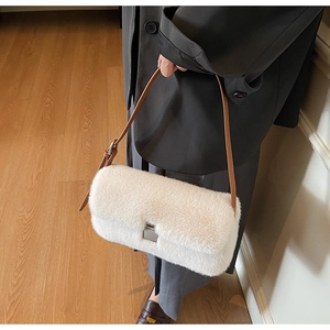 Detail of plush faux fur shoulder bag with leather strap and silver metal lock closure