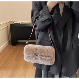 Close-up of khaki plush shoulder bag showing faux fur texture and brown leather strap