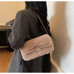 Detail of light brown faux fur shoulder bag featuring a silver metal square buckle closure