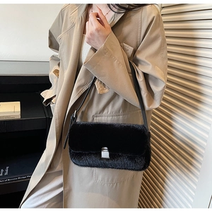 Close-up of black faux fur shoulder bag featuring a polished silver square metal buckle