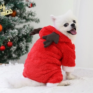 Chien Poméranien blanc portant un pyjama de Noël rouge pour chien avec bois de renne