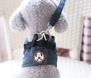Close-up of durable denim dog harness with metal shine badge and yellow stitching detail