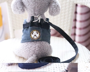 Close-up of denim dog harness with metal D-ring and SHINE patch on a white plush model