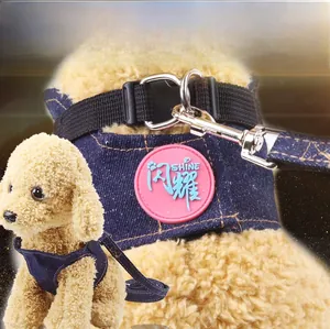 Detail of blue denim dog harness with yellow stitching and durable metal D-ring