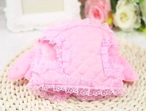 Close-up of pink quilted dog harness with delicate lace trim on a woven mat