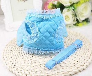 Detail of light blue quilted pet harness set with white lace and pearl wing accents
