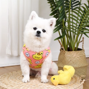 Pink breathable mesh dog vest with yellow duck pattern worn by a small white Pomeranian