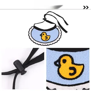 Detail of knitted pet bib showing cute duck embroidery and adjustable drawstring buckle