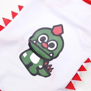 Detail of white mesh pet vest with green dinosaur print and red jagged trim decoration