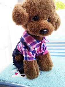 Detail of pink and blue plaid dog overalls with denim suspenders on a teddy plush toy