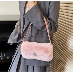 Detailed shot of pink faux fur shoulder bag with leather strap and silver buckle closure