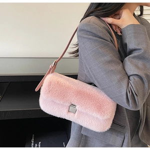 Pink fluffy faux fur shoulder bag with silver buckle worn over a grey checkered blazer