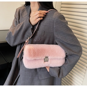 Detailed view of pink fuzzy plush bag with metallic buckle and slim leather strap