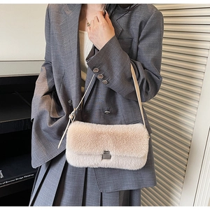 Detail of plush beige shoulder bag with silver metallic buckle and leather strap
