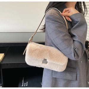 Close-up of beige faux fur shoulder bag with metal buckle and adjustable strap