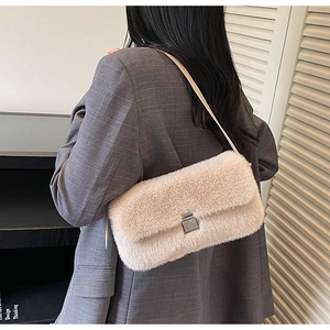 Detail of beige faux fur shoulder bag featuring silver square lock and soft texture