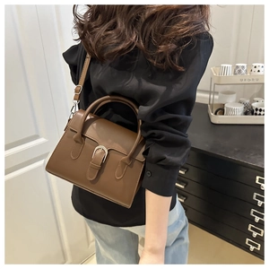 Brown matte faux leather handbag with adjustable strap and vintage silver buckle detail
