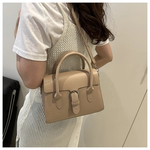 Detail view of khaki leather shoulder bag with buckle showing strap and side profile