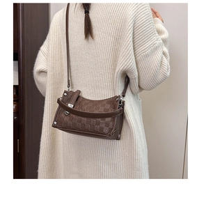 Detailed macro view of dark brown quilted leather texture and silver metallic buckle