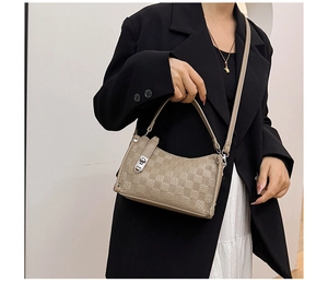 Detailed close-up of a beige quilted crossbody bag with a silver metal clasp and texture