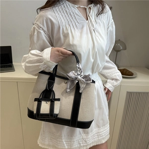 Contrast canvas tote bag with black leather trim and decorative silk scarf accessory