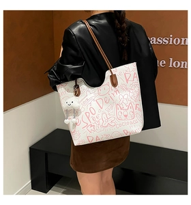 Detailed side view of the graffiti tote bag with cloud charm and pink cat patterns