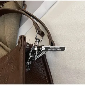 Detail of the dark brown leather bag showing the silver metal detachable strap hook