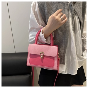 Detail of pink small square bag with textured flap and golden horseshoe buckle