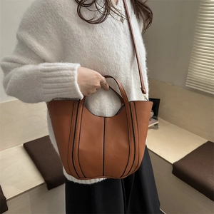 Brown bucket tote bag with vertical stripes and detachable strap for daily commuting
