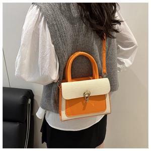 Detail of a retro color-block handbag showing woven texture and U-shaped metal buckle