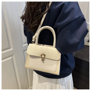 Detail of contrast stitching cross-body bag with woven texture and horseshoe metal clasp