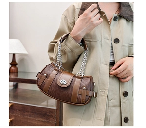 Detail of vintage brown pebble leather handbag with silver chain strap and twist lock