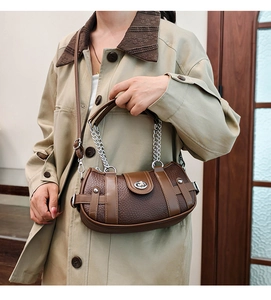 Close-up of vintage brown leather bag with metallic chain handle and secure twist lock