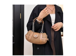 Detail of khaki pebbled leather handbag with silver chain and metal buckle closure
