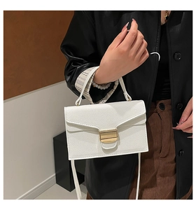 Détail du sac à main blanc en cuir grainé avec boucle dorée et bandoulière élégante