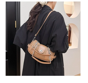 Detail of a brown lychee pattern leather shoulder bag with silver chain and twist lock