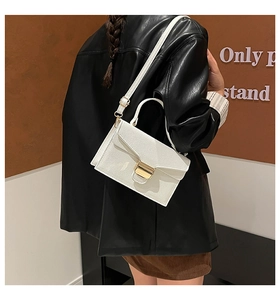 Détail d'un sac à main en cuir grainé blanc avec boucle dorée et bandoulière