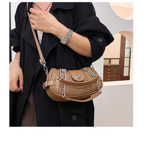 Detail of brown litchi pattern leather bag with silver chain and turn-lock closure