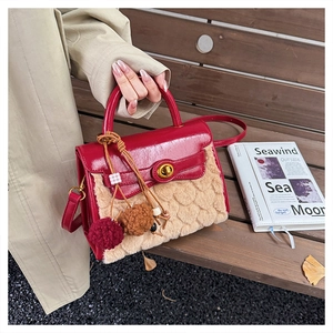 Detail of red leather and beige faux fur crossbody bag with golden twist lock on wooden bench