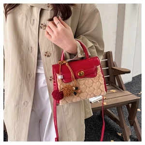 Detail of red leather flap and cream fleece bag with heart texture and gold twist lock