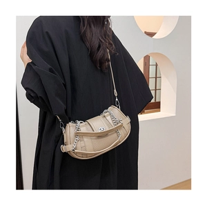 Detailed view of beige pebble leather shoulder bag with silver metal chain and twist lock